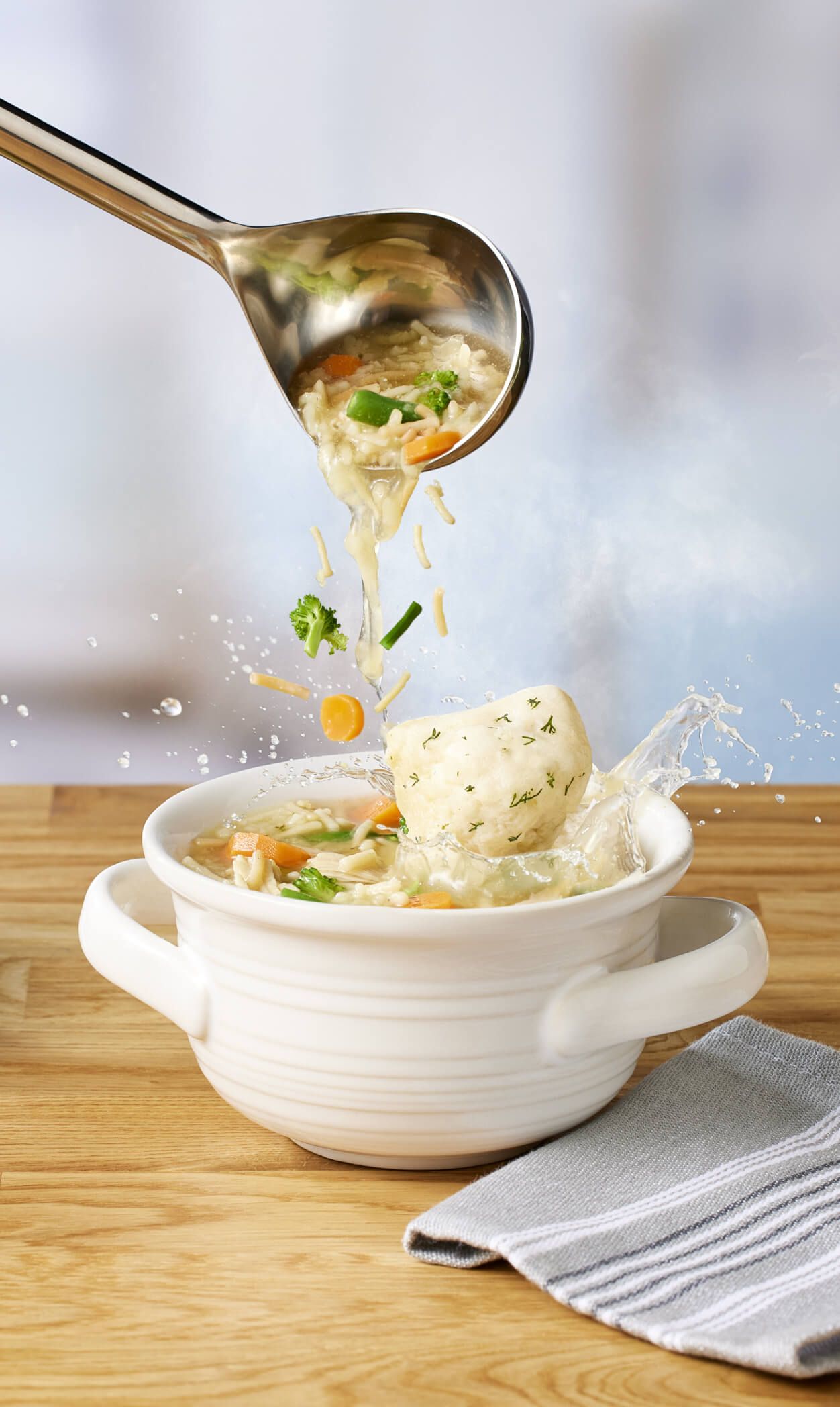 Spoon lifting dumpling from Turkey Veggie Soup bowl.